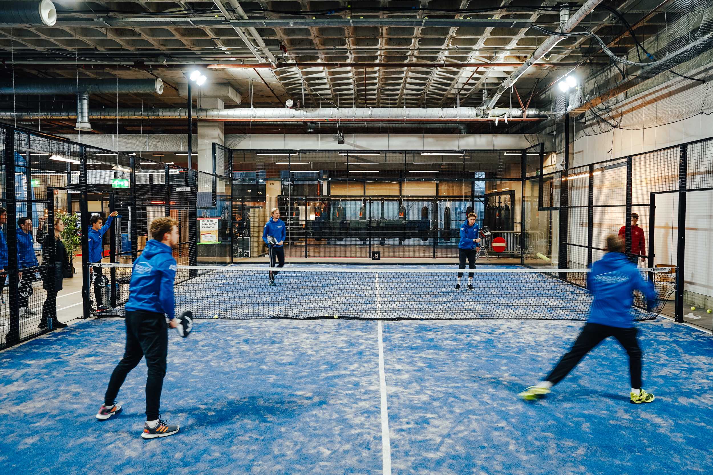 Vier spelers op een blauwe indoorbaan